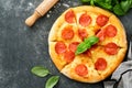 Pepperoni pizza. Traditional pepperoni pizza and cooking ingredients tomatoes basil on old concrete texture background table Royalty Free Stock Photo