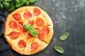 Pepperoni pizza. Traditional pepperoni pizza and cooking ingredients tomatoes basil on old concrete texture background table. Royalty Free Stock Photo