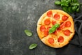 Pepperoni pizza. Traditional pepperoni pizza and cooking ingredients tomatoes basil on old concrete texture background table Royalty Free Stock Photo