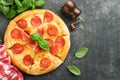 Pepperoni pizza. Traditional pepperoni pizza and cooking ingredients tomatoes basil on old concrete texture background table Royalty Free Stock Photo