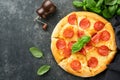 Pepperoni pizza. Traditional pepperoni pizza and cooking ingredients tomatoes basil on old concrete texture background table Royalty Free Stock Photo