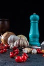 Peppers, olive oil and wooden mortar and more accessories on black background with selective focus