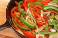 Peppers and onions in black cast iron skillet