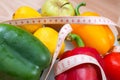 Peppers, tomatoes, apple and lemons on a scale with cutlery and Royalty Free Stock Photo