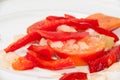 Peppers, tomatoes and onions cut for cooking on a plate