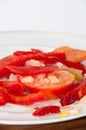 Peppers, tomatoes and onions cut for cooking on a plate