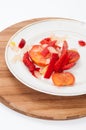 Peppers, tomatoes and onions cut for cooking on a wooden board