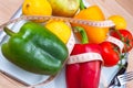 Peppers, tomatos, apple and lemons on a scale with cutlery and t Royalty Free Stock Photo