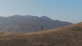 A peppy person is engaged in jogging mountains in the background aerial camera tracking