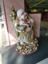 A standing old porcelain Buddha statue of Budai at the corridor entrance of the home