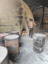 Scene of the worker putting mangrove logs into the charcoal kiln to produce pure carbon