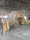 Scene of the worker putting mangrove logs into the charcoal kiln to produce pure carbon