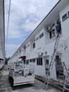 Worker climbed high up to the second storey building servicing the outlet air condition unit