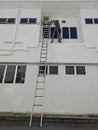 Worker climbed high up to the second storey building servicing the outlet air condition unit