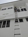 Worker climbed high up to the second storey building servicing the outlet air condition unit