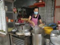 Outdoor scene of a lady preparing take back noodle as the customers waiting at Kg Koh favorite Noodle shop,