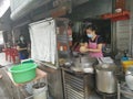 Outdoor scene of a lady preparing take back noodle as the customers waiting at Kg Koh favorite Noodle shop,