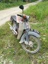 Vintage Motorcycle park outskirt of the plantation carrying long handle Hoe