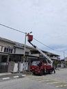 Outdoor scene of workers change streetlight bulb pole with the Rear-mount Ladder truck Royalty Free Stock Photo