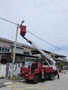 Outdoor scene of workers change streetlight bulb pole with the Rear-mount Ladder truck Royalty Free Stock Photo