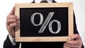 Percent sign drawn on blackboard in businessman hands, deposit interest rate