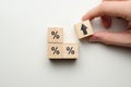 Percentage concept in finance raising with icons on wooden blocks