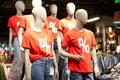 Percentage sign painted on a red t-shirt dressed on a mannequin stands in defocused store