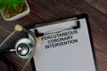 Percutaneous Coronary Intervention write on a paperwork isolated on Wooden Table Royalty Free Stock Photo