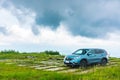 Modern suv on a grassy meadow in mountains