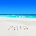 Perect white sandy ocean beach and season 2019 handwritten caption on sand