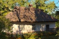 Scenic landscape view of small ancient clay house with a garden surrounded by a wicker fence in sunny autumn day Royalty Free Stock Photo