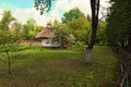 Wide angle landscape view of ancient clay house with a garden in sunny spring day. Royalty Free Stock Photo