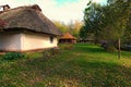 Reconstruction of an ancient clay house with thatched roof  front yard with outbuildings. Royalty Free Stock Photo