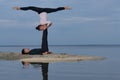 Perfect acroyoga. Beautiful young couple is doing yoga