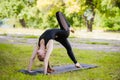 Perfect acroyoga. Beautiful young girl is balancing doing acro-yoga. Yoga flexibility outdoor class workout