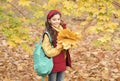 perfect autumn day of cheerful kid with school bag and autumn maple leaves arrangement walking in fall season park in Royalty Free Stock Photo