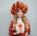 Perfect autumn woman in bright fall leaves crown holding red maple leaf Royalty Free Stock Photo