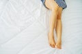 Perfect and beautiful crossed woman legs and feet on bed. Beautiful Slim and Sexy Young Woman Leg on Bed in Bedroom Royalty Free Stock Photo