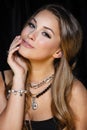 Perfect beauty and jewelry concept. Portrait of beautiful female model wearing ring, necklace and wristband on black