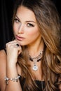 Perfect beauty and jewelry concept. Portrait of beautiful female model wearing ring, necklace and wristband on black