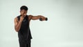 Perfect biceps. Muscular young african man exercising with dumbbells while standing against grey background Royalty Free Stock Photo