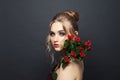 Perfect blonde woman with makeup and red berries plant