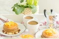 Perfect breakfast for 2. Tray with pancakes with orange jam and nuts on vintage plates and 2 white coffee cups