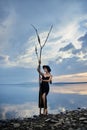 Perfect brunette beauty woman in a black hat and a black dress poses near a lake against a blue sky. Long hair woman and beautiful Royalty Free Stock Photo