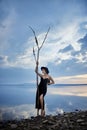 Perfect brunette beauty woman in a black hat and a black dress poses near a lake against a blue sky. Long hair woman and beautiful Royalty Free Stock Photo