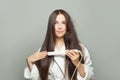 Perfect brunette woman straighten her hair with straightener on white background. Haircare concept Royalty Free Stock Photo