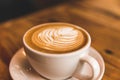 Perfect cappuccino in white cup on wood table