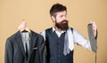 A perfect choice. Businessman choosing necktie, choice concept. Bearded man matching tie color to suit jacket in store