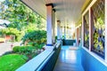 Perfect covered front porch with decorative windows, and greenery.