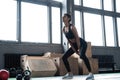 Side view of young beautiful woman with perfect body in sportswear working out with kettle bell at gym. Royalty Free Stock Photo